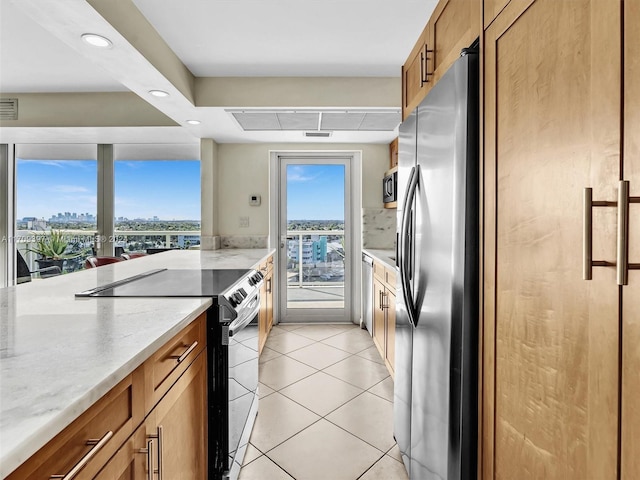 kitchen featuring light stone counters, light tile patterned floors, and stainless steel appliances