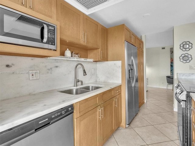 kitchen featuring backsplash, light tile patterned floors, sink, and appliances with stainless steel finishes