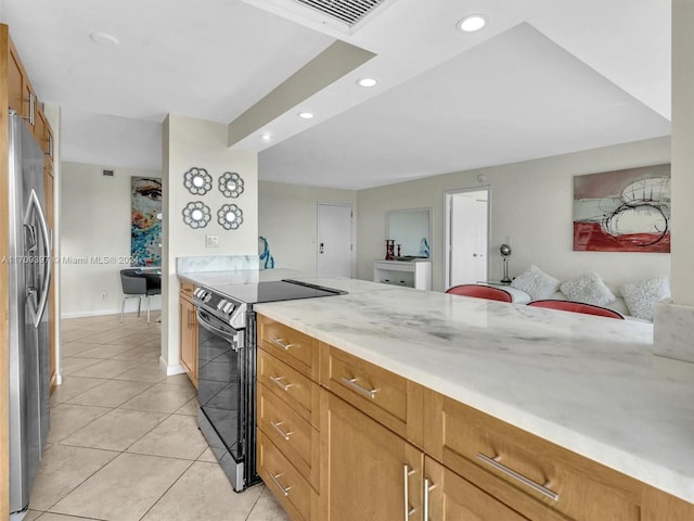 kitchen with stainless steel refrigerator, electric stove, and light tile patterned floors