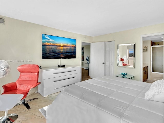 bedroom with ensuite bathroom, a closet, and light tile patterned flooring