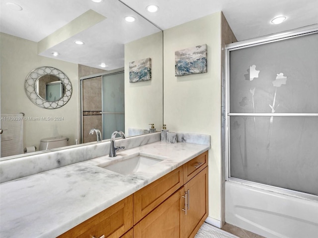 full bathroom with tile patterned floors, vanity, toilet, and bath / shower combo with glass door