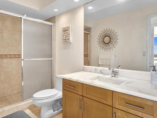 bathroom featuring tile patterned flooring, vanity, a shower with door, and toilet