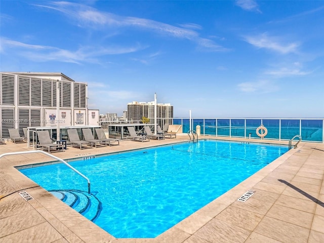 view of swimming pool featuring a patio area and a water view