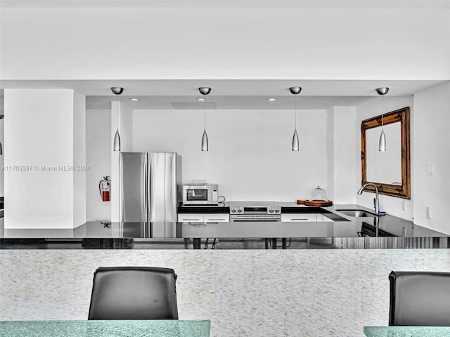 kitchen featuring sink, stainless steel appliances, and hanging light fixtures