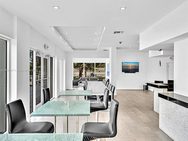 tiled dining room featuring french doors and a healthy amount of sunlight