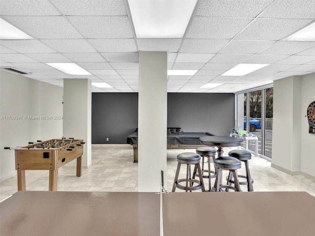 game room featuring a paneled ceiling and light tile patterned flooring