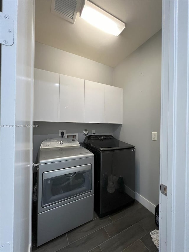 washroom with cabinets, dark hardwood / wood-style floors, and washer and dryer