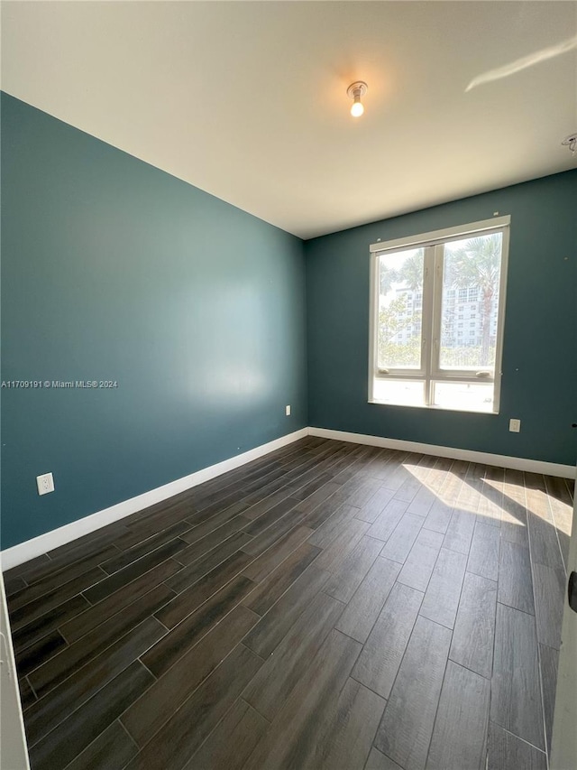 unfurnished room featuring dark hardwood / wood-style flooring