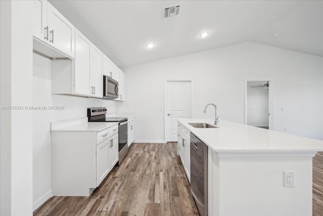 kitchen featuring white cabinets, ceiling fan, appliances with stainless steel finishes, and vaulted ceiling