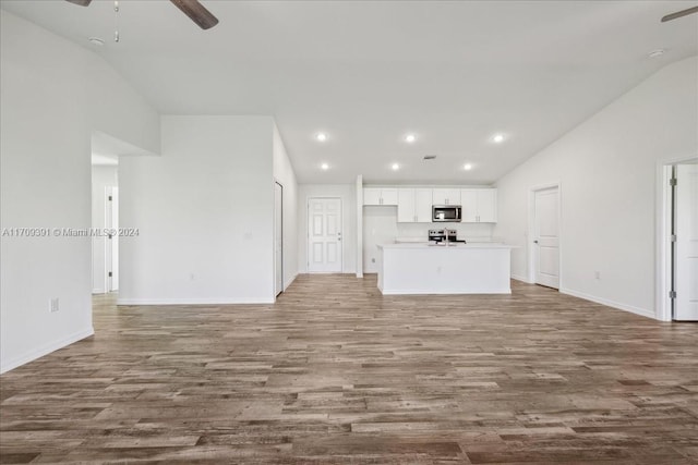 unfurnished living room with ceiling fan, vaulted ceiling, and hardwood / wood-style flooring