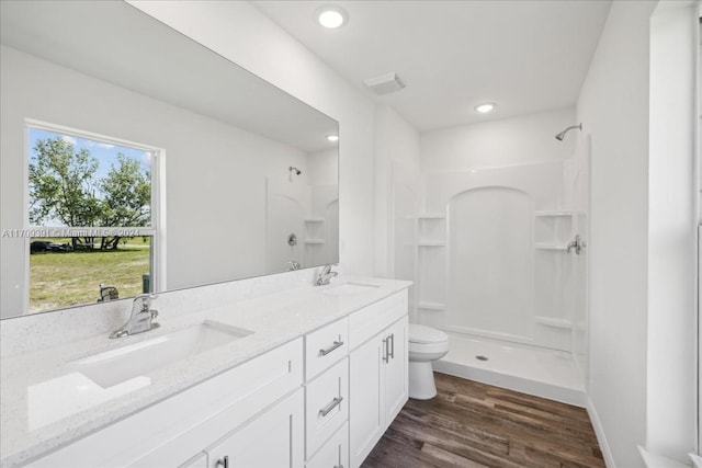 bathroom with a wealth of natural light, a shower, wood-type flooring, and toilet