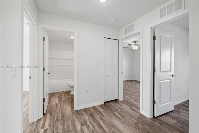 unfurnished bedroom with light hardwood / wood-style flooring, ensuite bath, and a closet