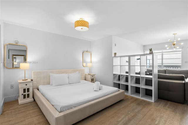 bedroom featuring light hardwood / wood-style floors and an inviting chandelier