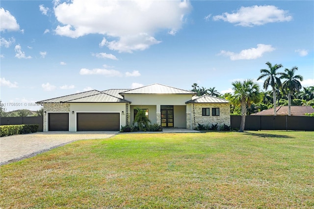 view of front of home with a garage and a front lawn