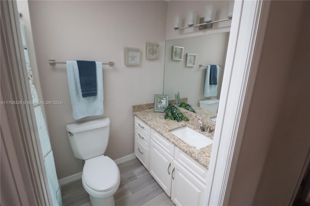 bathroom featuring hardwood / wood-style floors, vanity, and toilet