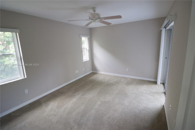 unfurnished bedroom with light colored carpet, multiple windows, and ceiling fan