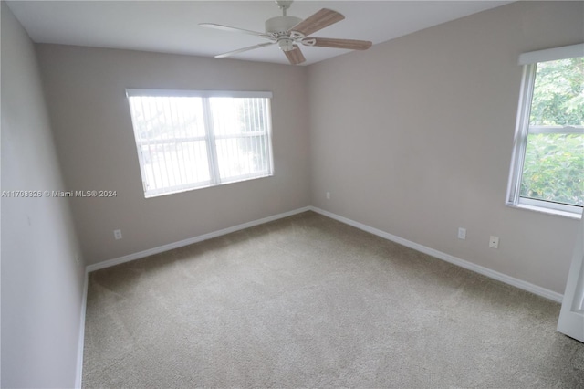 unfurnished room with carpet flooring, ceiling fan, and a healthy amount of sunlight