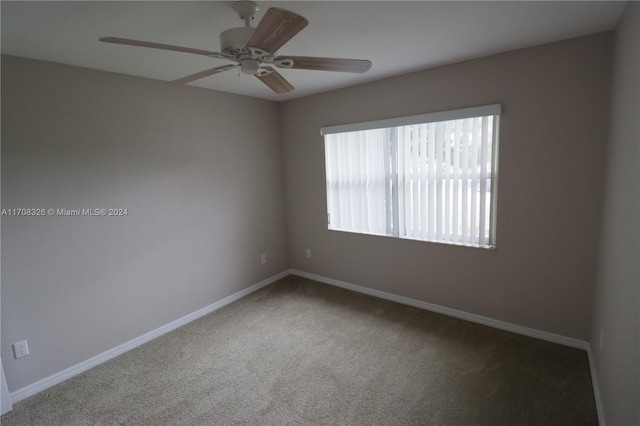 spare room with ceiling fan and carpet