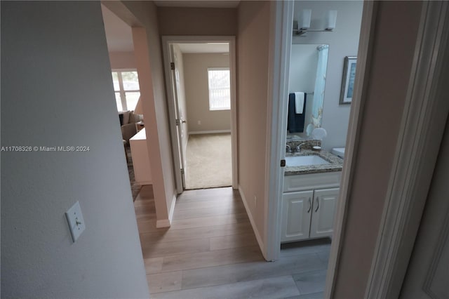 hall featuring sink and light wood-type flooring