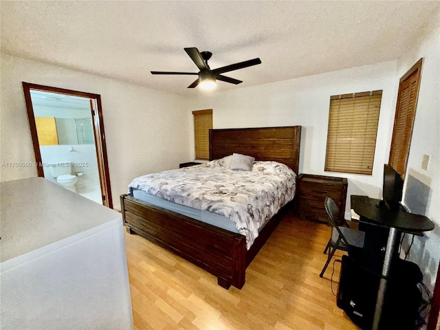 bedroom featuring ceiling fan, light wood-type flooring, connected bathroom, and a textured ceiling