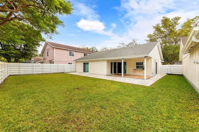 rear view of house featuring a yard and a patio