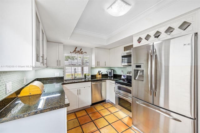 kitchen featuring decorative backsplash, white cabinetry, sink, and stainless steel appliances