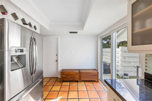 kitchen featuring a raised ceiling, stainless steel fridge with ice dispenser, ornamental molding, and light tile patterned floors