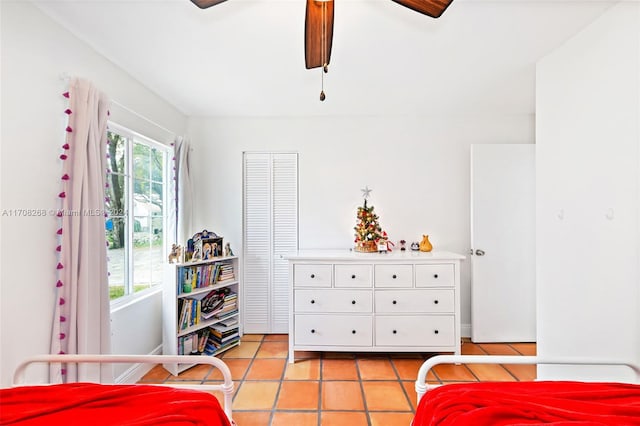 bedroom with ceiling fan, a closet, and light tile patterned floors