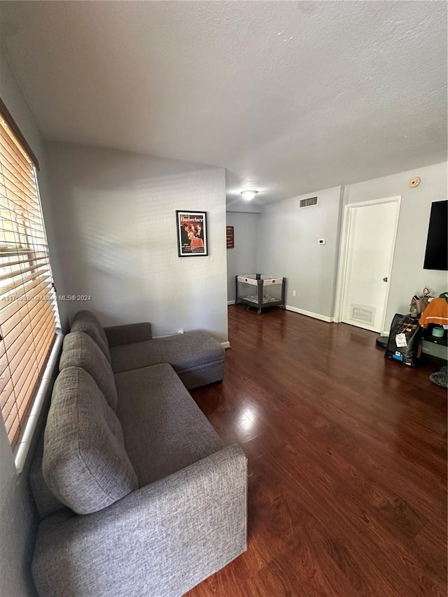 living room featuring a textured ceiling and dark hardwood / wood-style floors