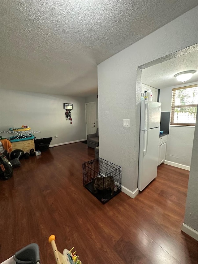 interior space with a textured ceiling and dark hardwood / wood-style flooring