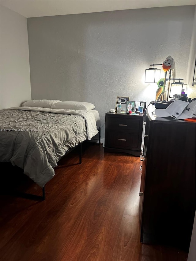 bedroom featuring washer and dryer and dark wood-type flooring