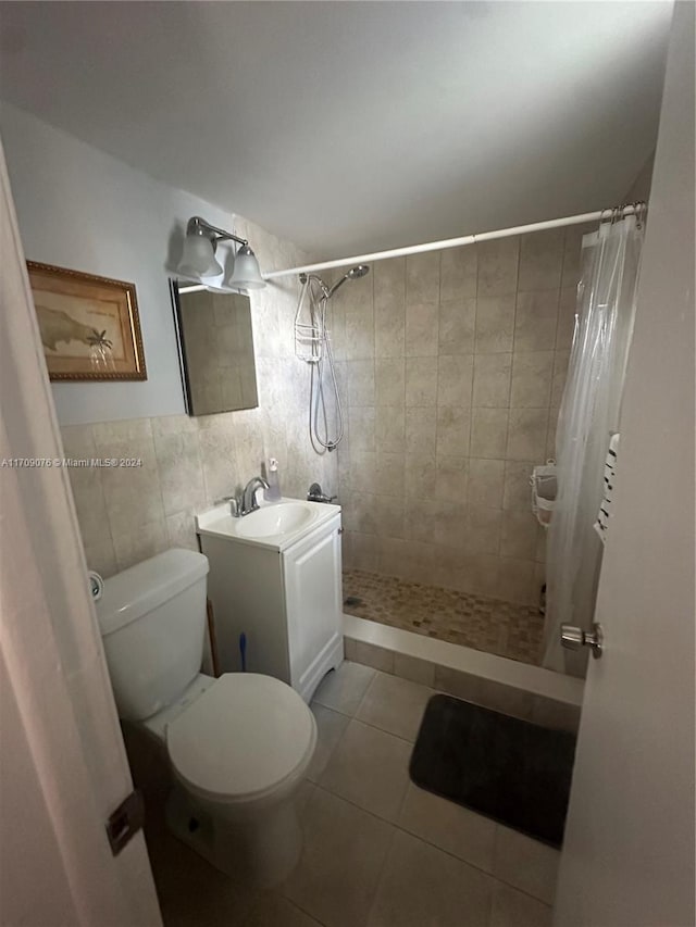 bathroom featuring tile patterned floors, a shower with curtain, vanity, tile walls, and toilet