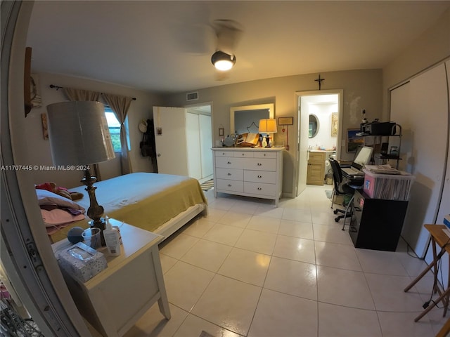 bedroom with light tile patterned floors and connected bathroom