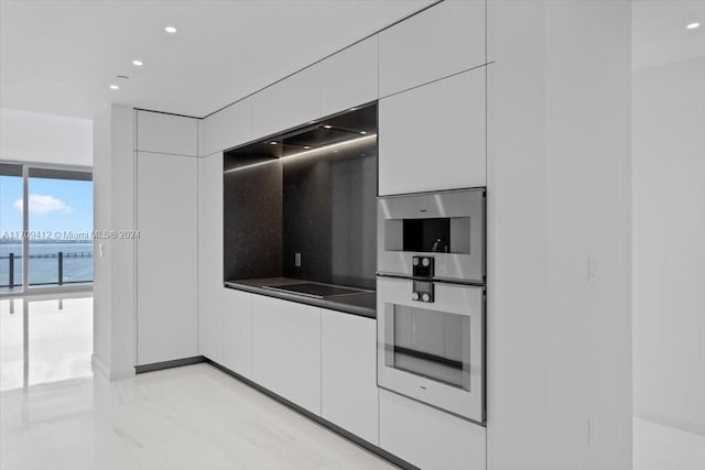 kitchen featuring a water view, white cabinetry, stainless steel double oven, and black electric cooktop