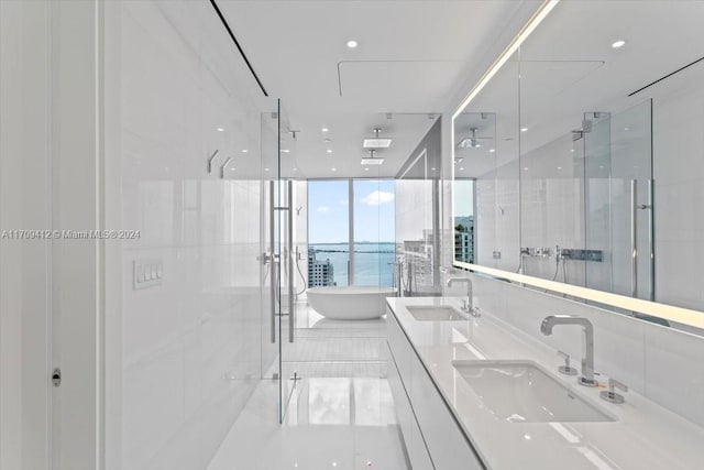 bathroom with tile patterned floors, vanity, plus walk in shower, and a water view