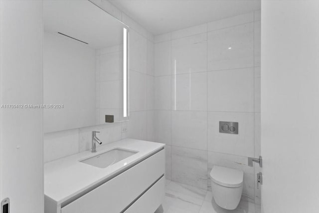 bathroom with vanity, toilet, and tile walls