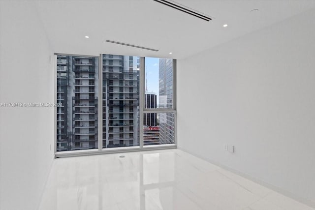 empty room featuring tile patterned floors and floor to ceiling windows