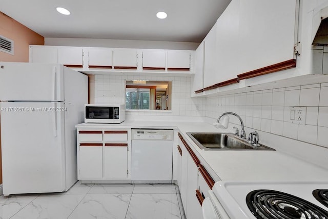 kitchen featuring backsplash, sink, white cabinets, and white appliances