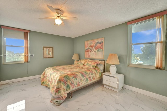 bedroom featuring multiple windows, a textured ceiling, and ceiling fan