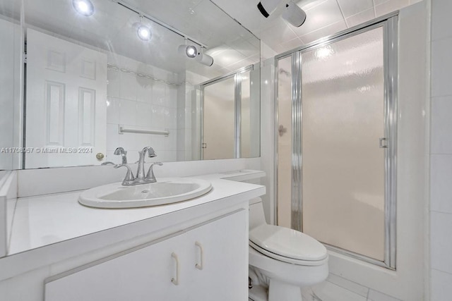 bathroom featuring vanity, toilet, and a shower with shower door