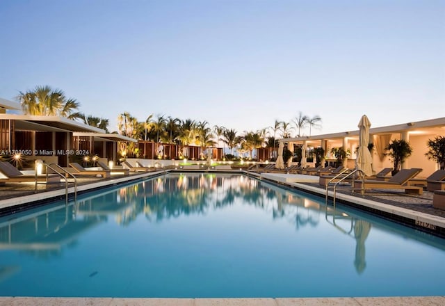 pool at dusk with a patio area