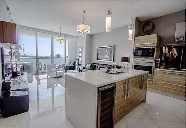 kitchen featuring black microwave, a center island, beverage cooler, oven, and a water view