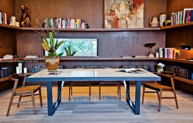 dining space featuring hardwood / wood-style flooring and wood walls