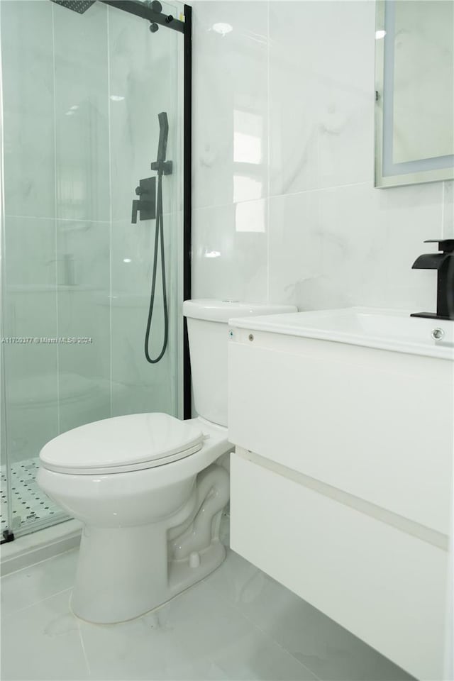 bathroom with vanity, an enclosed shower, tile walls, and toilet