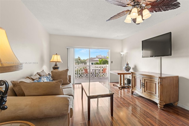 living room featuring a textured ceiling, dark hardwood / wood-style floors, and ceiling fan