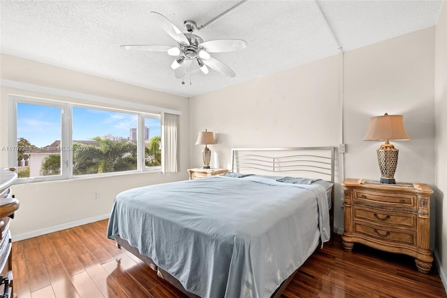 bedroom featuring ceiling fan, dark hardwood / wood-style floors, and a textured ceiling