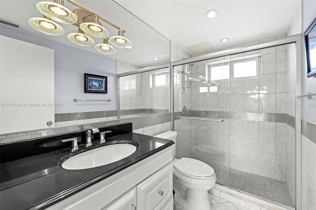 bathroom featuring vanity, a shower with shower door, and toilet