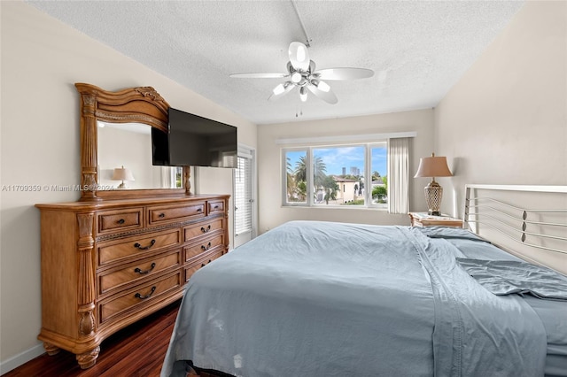 bedroom featuring wood-type flooring, a textured ceiling, and ceiling fan