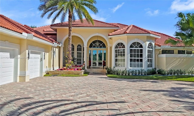 back of property featuring french doors and a garage