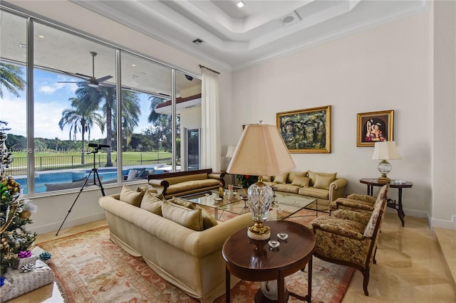 living room with ornamental molding and a raised ceiling